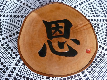丸太の輪切り板に彫られた「恩」という文字