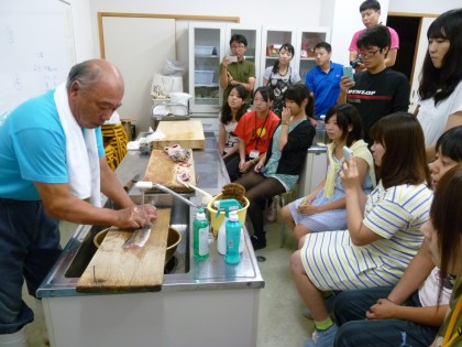 組合長の見事な包丁捌きに見入る参加者